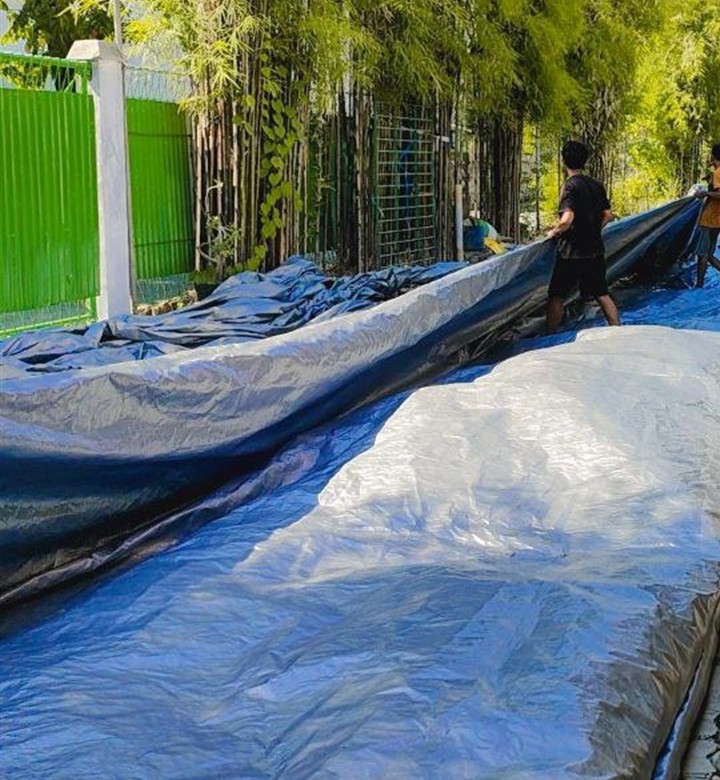 Terpal ukuran jumbo sedang dilipat dan dirapikan di area pabrik Prima Terpal Surabaya